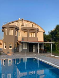 a house with a swimming pool in front of it at Triplex Villa with Pool PATERA VILLA in Serik