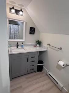 a bathroom with a sink and a mirror at Seacoast Apartment in Windham