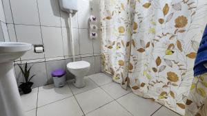 a bathroom with a toilet and a shower curtain at Casa Andorinha in Lençóis +37 photos
