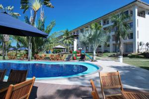 a resort with a pool and chairs and a building at ARAGUAIA HOTEL in Barra do Garças