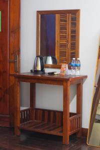 a wooden table with a mirror on a wall at Good Vibes in Siem Reap