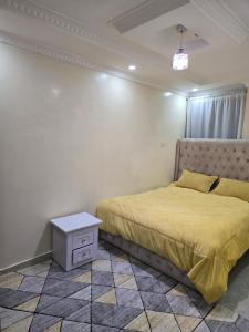 ein Schlafzimmer mit einem Bett mit einer gelben Tagesdecke und einem Tisch in der Unterkunft Haven Homes in Ruiru