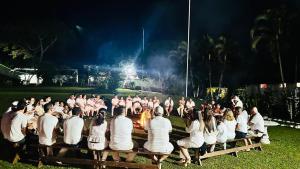 a group of people sitting around a fire at night at Hotel Campestre Villa Nazareth in Pueblorrico
