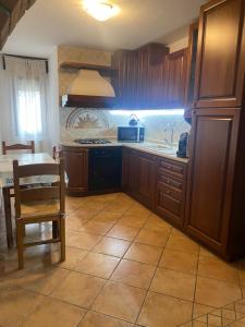 a kitchen with wooden cabinets and a table and a sink at Appartamento 'Diva Canova Laguna Veneta' in Santa Margherita
