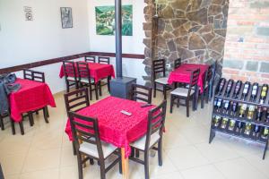 um restaurante com mesas vermelhas e cadeiras num quarto em Hotel Kalaja em Berat