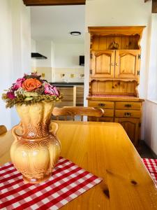 a vase with flowers on a table in a kitchen at Apartma Špan in Zgornje Gorje +5 photos
