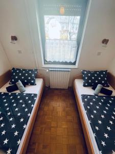 two beds in a small room with a window at Apartma Špan in Zgornje Gorje