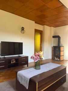 a living room with a vase of flowers on a table at Apartma Špan in Zgornje Gorje