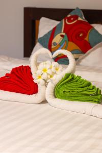 two towels on a bed with flowers in them at Good Vibes in Siem Reap