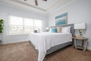 a white bedroom with a large bed and a window at Be A Nomad - Combined Home for Groups II - Steps to Ocean in Jacksonville Beach