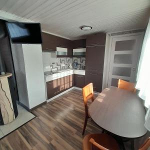 a kitchen with a wooden table and a dining room at Jaukus namas šalia Klaipėdos in Kiškėnai +18 photos