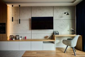 a room with a desk with a television and a chair at EASY RENT Apartments- Unia Art Residence 130, Basen & SPA, Centrum Free Parking 24h Check-in in Lublin