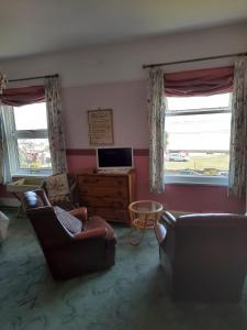 Una sala de estar con dos sofás y un televisor. en Sea view flat at Claverton House, en Ryde
