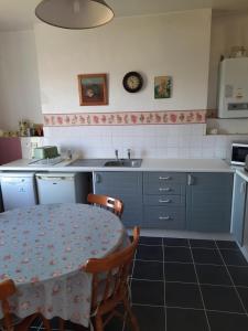 cocina con mesa, fregadero, mesa y sillas en Sea view flat at Claverton House, en Ryde 1 foto más
