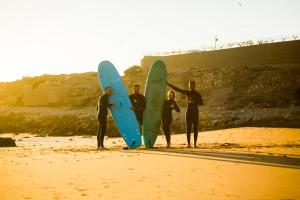a group of people standing on the beach with surfboards at Surf and Stay Anza - Surf Territory in Agadir