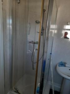 una ducha con una puerta de cristal junto a un lavabo en Sea view flat at Claverton House, en Ryde