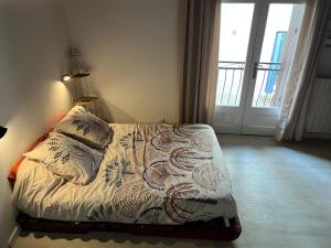 a bedroom with a bed with a lamp and a window at Saint-Gilles Appartement in Saint-Gilles