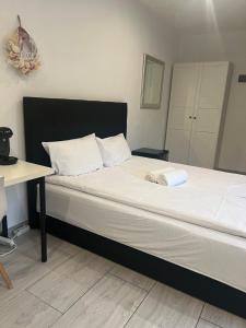 a bed with a black frame and white sheets at Apartament Stara Piekarnia in Tychy