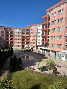 a playground in a park in front of a building at Privilege First Line Sea in Elenite