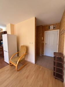 a living room with a chair and a refrigerator at Privilege First Line Sea in Elenite