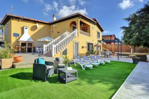 dom z ogródkiem z krzesłami i trawą w obiekcie Apartment Private Heated Pool w mieście El Draguito