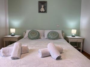 a bed with two pillows on it with two tables at SA nest in Spetses