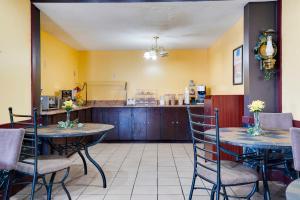 a restaurant with two tables and chairs and a counter at OYO Hotel Wade/Fayetteville I-95 South in Eastover +35 photos