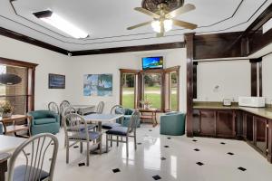 a dining room with tables and chairs and a ceiling fan at Three Rivers Executive Inn & Suites By OYO in Three Rivers