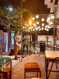 a woman is playing a guitar in a room at Good Vibes in Siem Reap