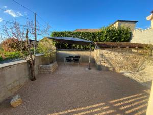 a patio with a table and an umbrella at Petite maison en pierre au calme avec extérieur in Montbellet +2 photos