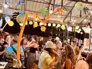 a crowd of people standing under a tent with balloons at Good Vibes in Siem Reap