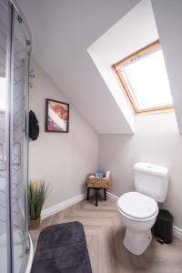 ein Bad mit einem WC und einem Dachfenster in der Unterkunft Serenity House, Whitehall Ballycastle in Ballycastle + 13 Fotos
