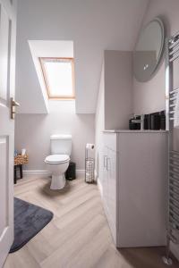 ein weißes Badezimmer mit Toilette und Waschbecken in der Unterkunft Serenity House, Whitehall Ballycastle in Ballycastle