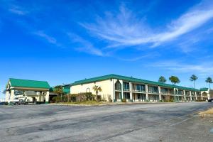 an empty parking lot in front of a hotel at Super Inn & Suites by OYO Milledgeville in Milledgeville