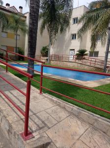 a red railing in front of a swimming pool at apartamento con piscina in Les Cases d'Alcanar +26 photos
