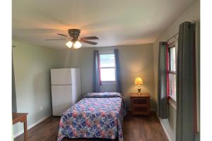 ein Schlafzimmer mit einem Bett und einem Deckenventilator in der Unterkunft Werry's Cottages and Pub By OYO East Stroudsborg - Weekly Stays in East Stroudsburg