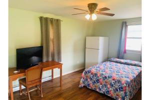 ein Schlafzimmer mit Schreibtisch, Bett und Fernseher in der Unterkunft Werry's Cottages and Pub By OYO East Stroudsborg - Weekly Stays in East Stroudsburg