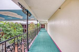 a corridor of a building with a green floor at OYO Townhouse Tulsa Woodland Hills in Tulsa