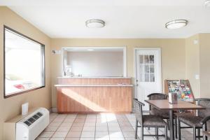 a restaurant with a bar and a table and chairs at OYO Hotel Tulsa International Airport in East Tulsa