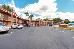 a large building with cars parked in a parking lot at OYO Hotel Mustang Silver Spring FL in Silver Springs