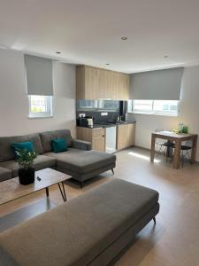 a living room with two couches and a kitchen at Living Boutique Apartments Adults Only in Ayia Napa