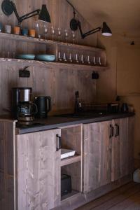 ŁawkiWolny Las Glamping na Mazurach的厨房配有带锅碗瓢盆的木橱柜
