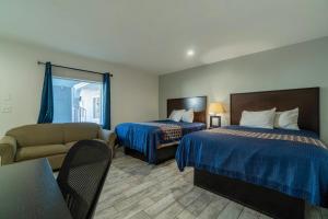 アランサス・パスにあるPelican Inn by Belvilla Aransas Pass, TXのベッド2台とソファがあるホテルの部屋