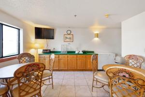 a kitchen with a table and chairs and a refrigerator at OYO Hotel Portage I-94 in Portage