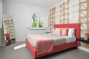 a bedroom with a bed with a red headboard at Villa Ketty Resort in Vico Equense