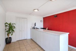 a kitchen with a counter and a red wall at OYO Hotel Cleveland, TN in Cleveland