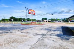 a sign for a fast food restaurant in a parking lot at Travel Inn by OYO, Hwy 80 - Jackson in Jackson