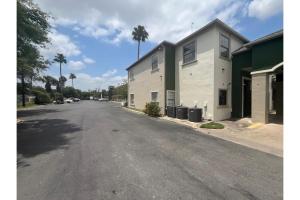 an empty street next to a building with palm trees at La Posada Inn By OYO Brownsville in Brownsville