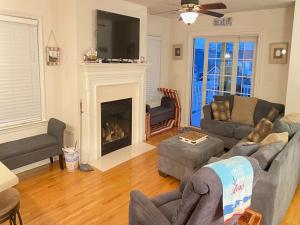 a living room with a couch and a fireplace at Roof-Top Deck With Ocean & Bay Views Single Family Beach Badges Private Yard Ping Pong And Pool Table Wifi 1 Block From Ocean 15 Blocks To Bay in Ship Bottom