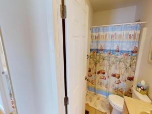 a bathroom with a shower curtain and a toilet at Roof-Top Deck With Ocean & Bay Views Single Family Beach Badges Private Yard Ping Pong And Pool Table Wifi 1 Block From Ocean 15 Blocks To Bay in Ship Bottom +25 photos